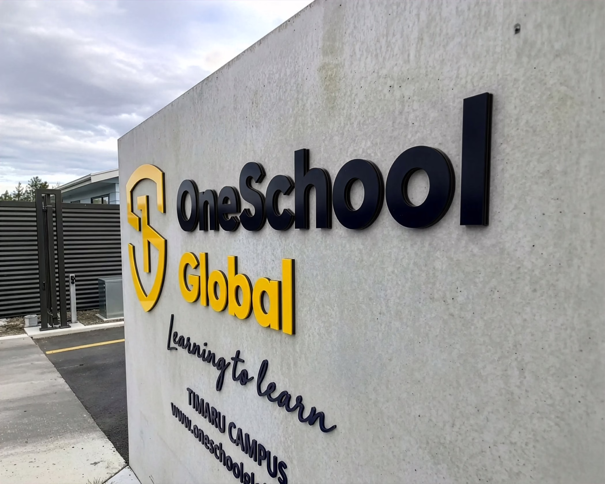 Custom 3D black and yellow entrance wall signage installed for OneSchool Global Timaru Campus by Timaru Signs Graphix.