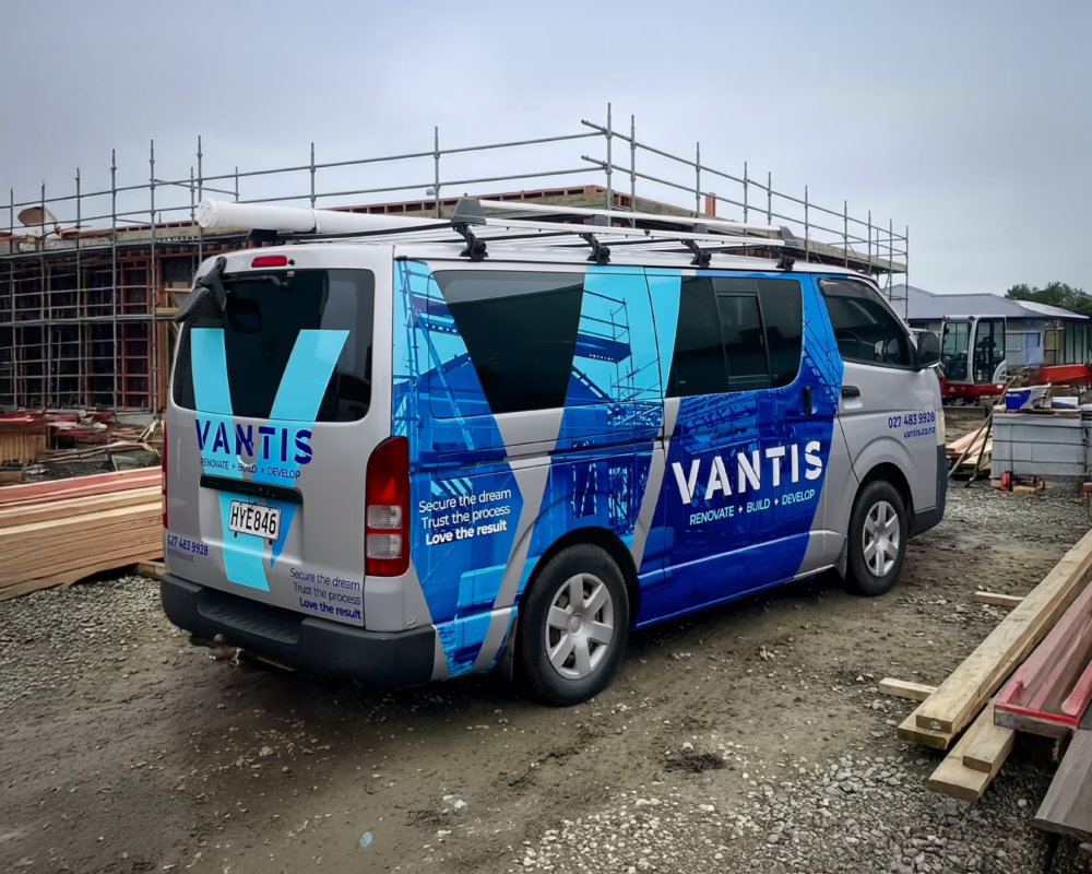 Custom vehicle wrap on a silver van for Vantis by Timaru Signs, featuring a blue geometric architectural design.