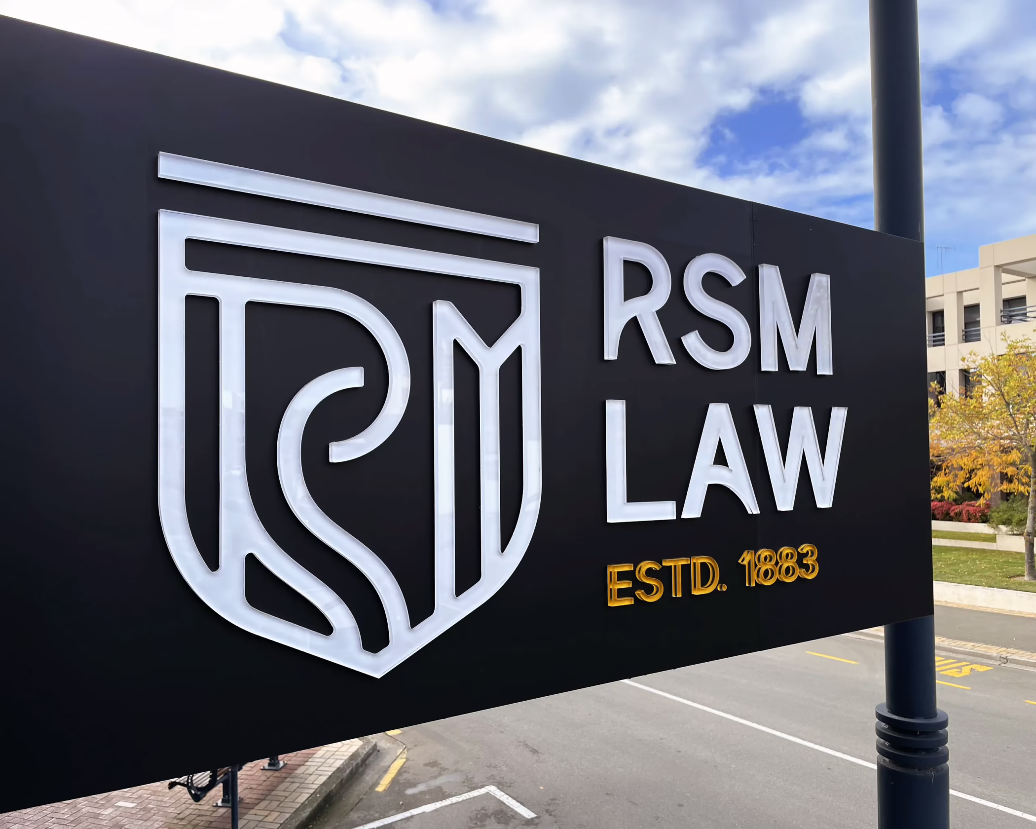 3D custom signage for RSM Law, Timaru, featuring dimensional logo on a matte black background, established 1883.