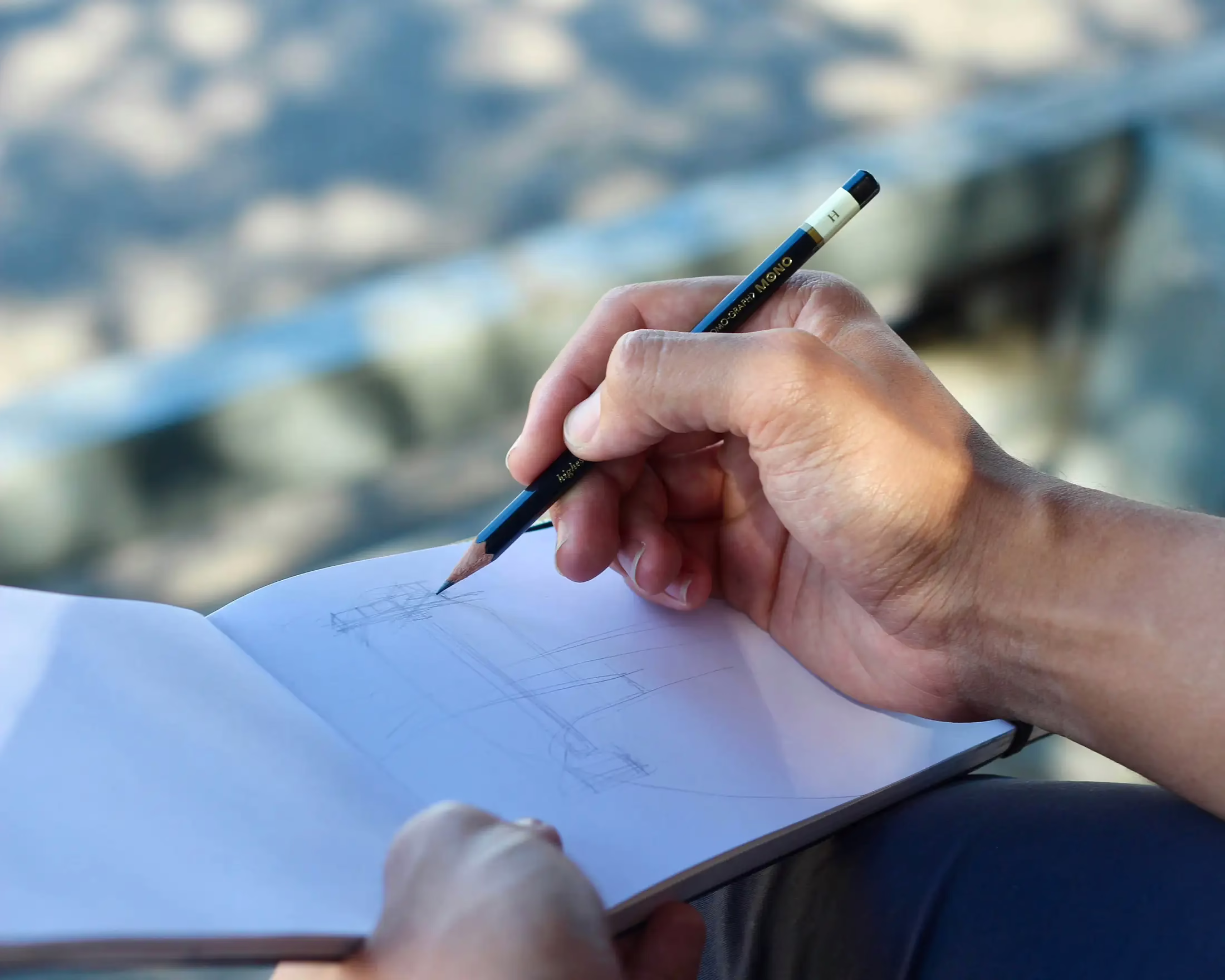 Hand-sketching a custom signage concept with a pencil for Timaru Signs Graphix.