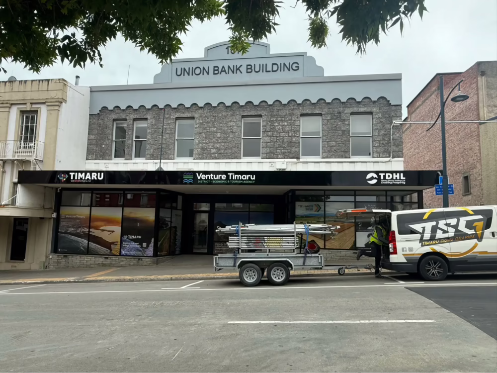 Exterior building fascia sign for Venture Timaru and TSG vehicle graphics on van in front of Union Bank Building.