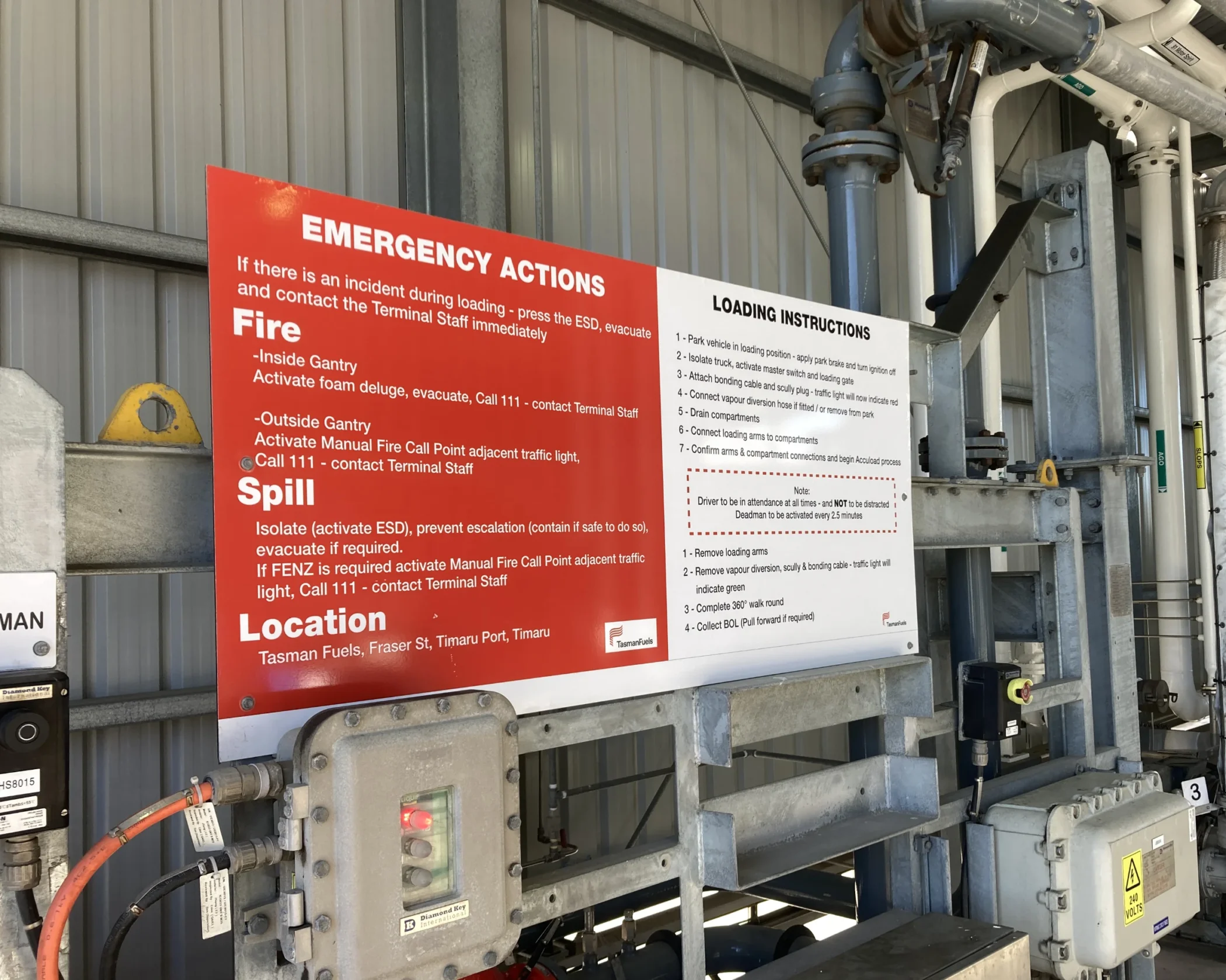 Large custom industrial safety sign in red and white with Tasman Fuels contact details.